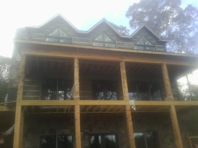 Dormers and porch framing on a large log home under construction — Roof Coating work by our crew in Autryville