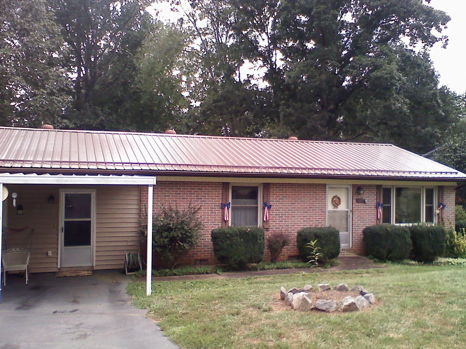 Bronze metal roof and carport on a brick ranch home — Roof Repair work by our crew in Autryville